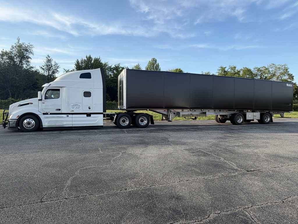 A CARVI tractor coupled to a rolling-tarp flatbed trailer.